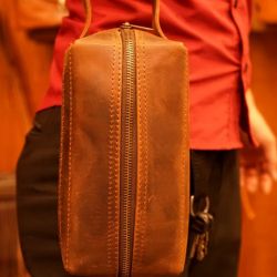 Real Leather Hoi An - Da Bao Real Leather: Brown buffalo leather toiletry bag, held on handle. The bag can also be used as purse.