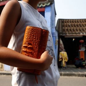 Hoi An Real Leather - Da Bao Real Leather: light-brown crocodile wallet, closing with a press button. Photo taken in front of our leather shop in the Old Town of Hoi An.
